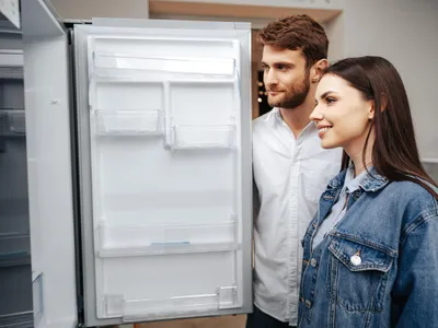 Un cuplu tânăr alege un frigider nou într-un magazin de electrocasnice - Foto: Magnific.com (Imagine cu rol ilustrativ)