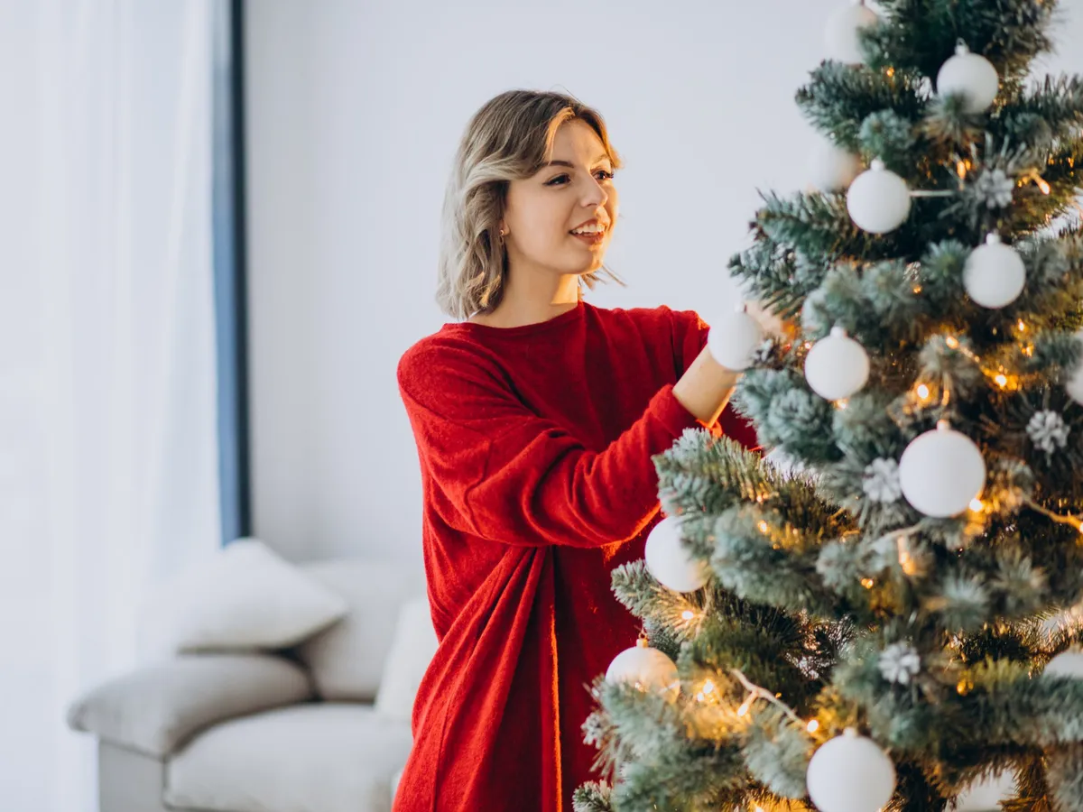 Femeie care împodobește bradul - Foto: Freepik (Imagine cu rol ilustrativ)