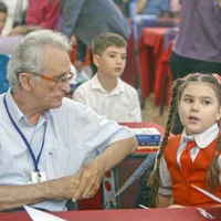 Cristian Gațu, alături de o elevă care învață să scrie caligrafic. Foto Octavian Cocoloș