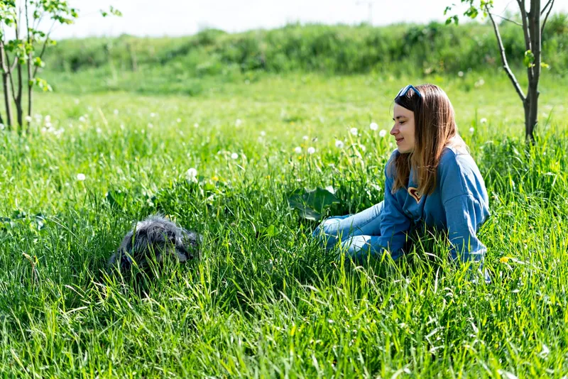 Femeie care stă &icirc;n iarbă - Foto: Magnigic.com (Imagine cu rol ilustrativ)