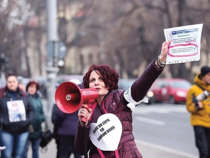 Mădălina Turza,   la un protest în fața Guvernului, față de adoptarea „bugetului zero“ pentru persoanele cu dizabilități. Sute de oameni le-au cerut pesediștilor „să nu atenteze la supraviețuirea a sute de mii de de persoane cu dizabilități”