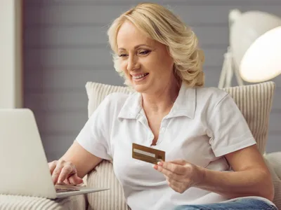 Femeie la pensie verifică cardul - Foto: Freepik