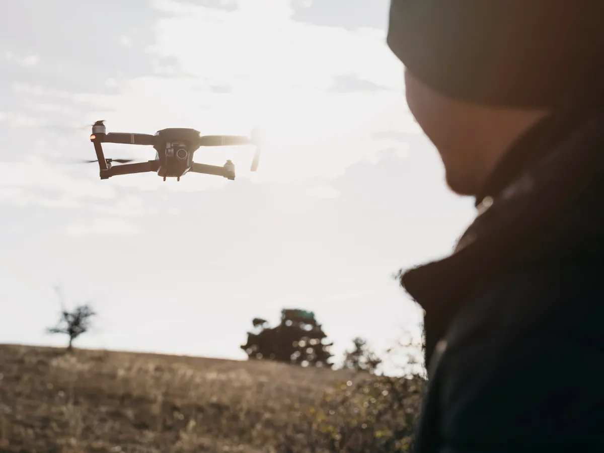 Bărbat în prim-plan care urmărește o dronă - Foto: Magnific.com (Imagine cu rol ilustrativ)