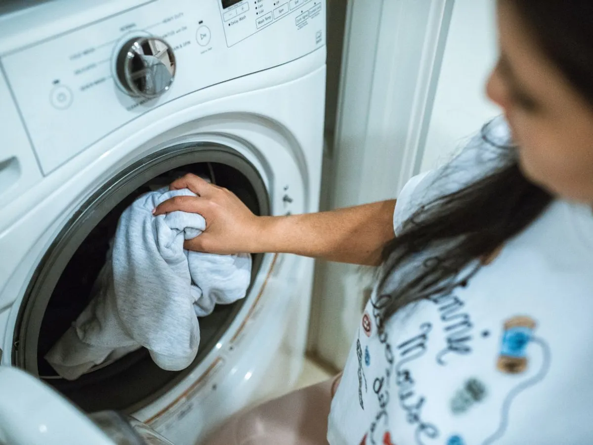 Femeie care pornește mașina de spălat rufe - Foto: Pexels (Imagine cu rol ilustrativ)