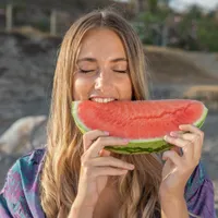 Femeie frumoasă care mănâncă o bucată de pepene roșu - Foto: Freepik