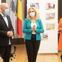 Ex-primărița Gabriela Firea, cu ex-vicele Aurelian Bădulescu, la înmânarea repartițiilor într-un bloc neterminat. Pe fundal, se vede cum ar urma să arate apartamentele. FOTO: PMB