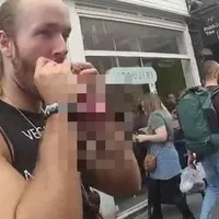 Gatis Lagzdins purta un tricou cu mesajul "Veganism = malnutriție" atunci protesta în afara unei piețe de produse alimentare vegane/Foto: BBC
