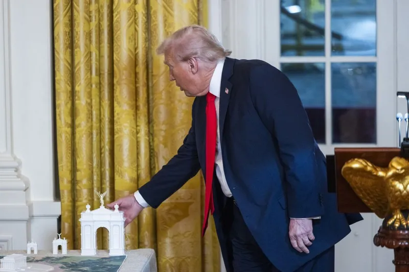 Donald Trump atinge o machetă a Arcului de Triumf pe care vrea să-l construiască - Foto: Profimedia Images