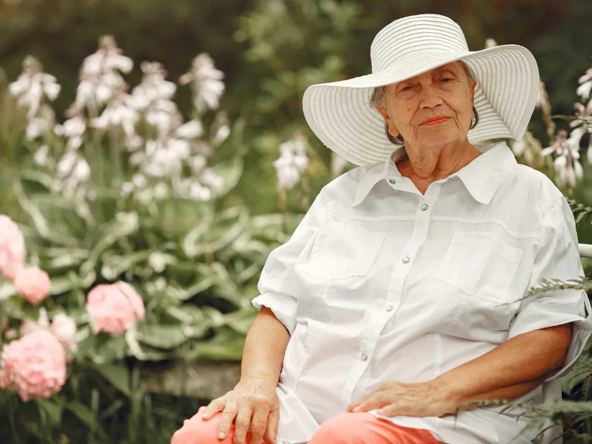 Pensionară îmbrăcată cu o bluză albă, lejeră în grădină - Foto: Magnific.com (Imagine cu rol ilustrativ)