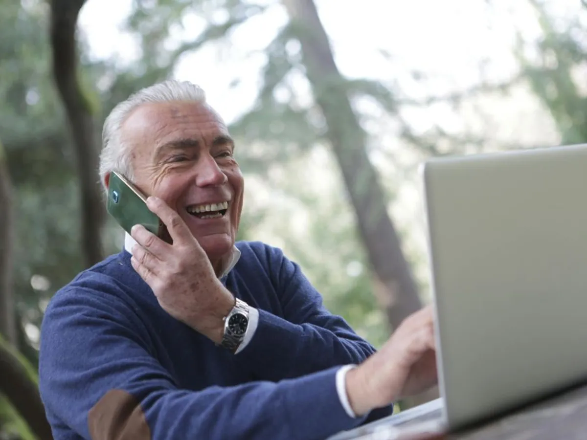 Bărbat în etate vorbind la telefon şi, simultan, navigând pe Internet - Foto: Pexels/Andrea Piacquadio