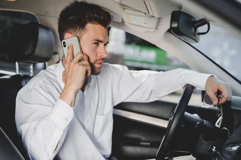 Un șofer vorbește la telefon fără handsfree - Foto: magnific.com (Imagine cu rol ilustrativ)
