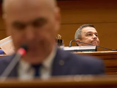 Premierul Ilie Bolojan vorbeşte, în plenul Parlamentului. Sorin Grindeanu ascultă, vădit nemulţumit - Foto: Profimedia Images