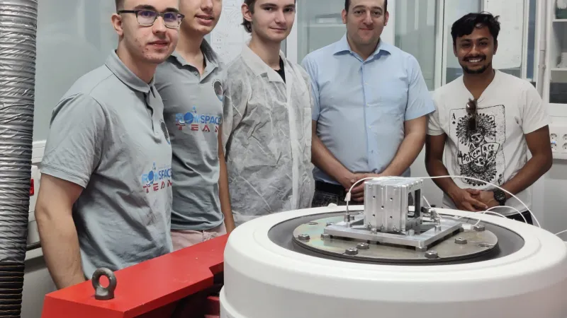 Alexandru Luchianov, Filip Bușcu, David Constantinescu (RomSpace), alături de Felix Paez (AMSAT) și Saurav Paudel (Orion Space) în laboratorul Institutului de Microgravitație de la UPM. În centru, satelitul ROM-2 la finalul testelor. / Foto: RomSpace