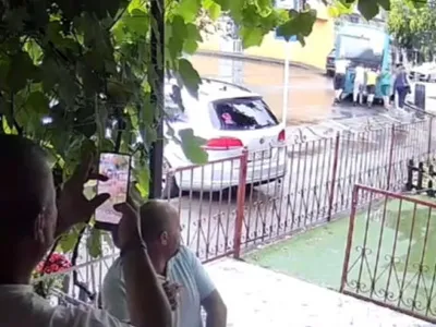 Mai multe femei împing un microbuz blocat în trafic în Galați, în timp ce bărbați aflați la terasă filmează și comentează