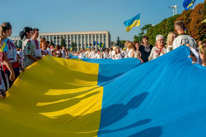 Persoane care țin drapelul Ucrainei - Foto: Freepik (rol ilustrativ)