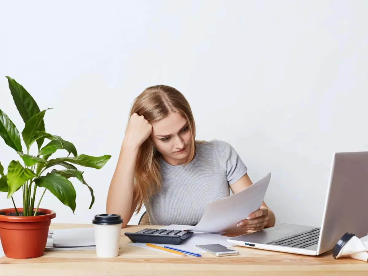 Femeie frumoasă calculându-şi impozitul pe venit - Foto: Magnific.com/user18526052