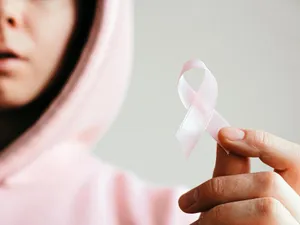 Femeie purtând o panglică roz, simbolul suferinzilor de cancer - Foto: Pexels/Anna Shvets