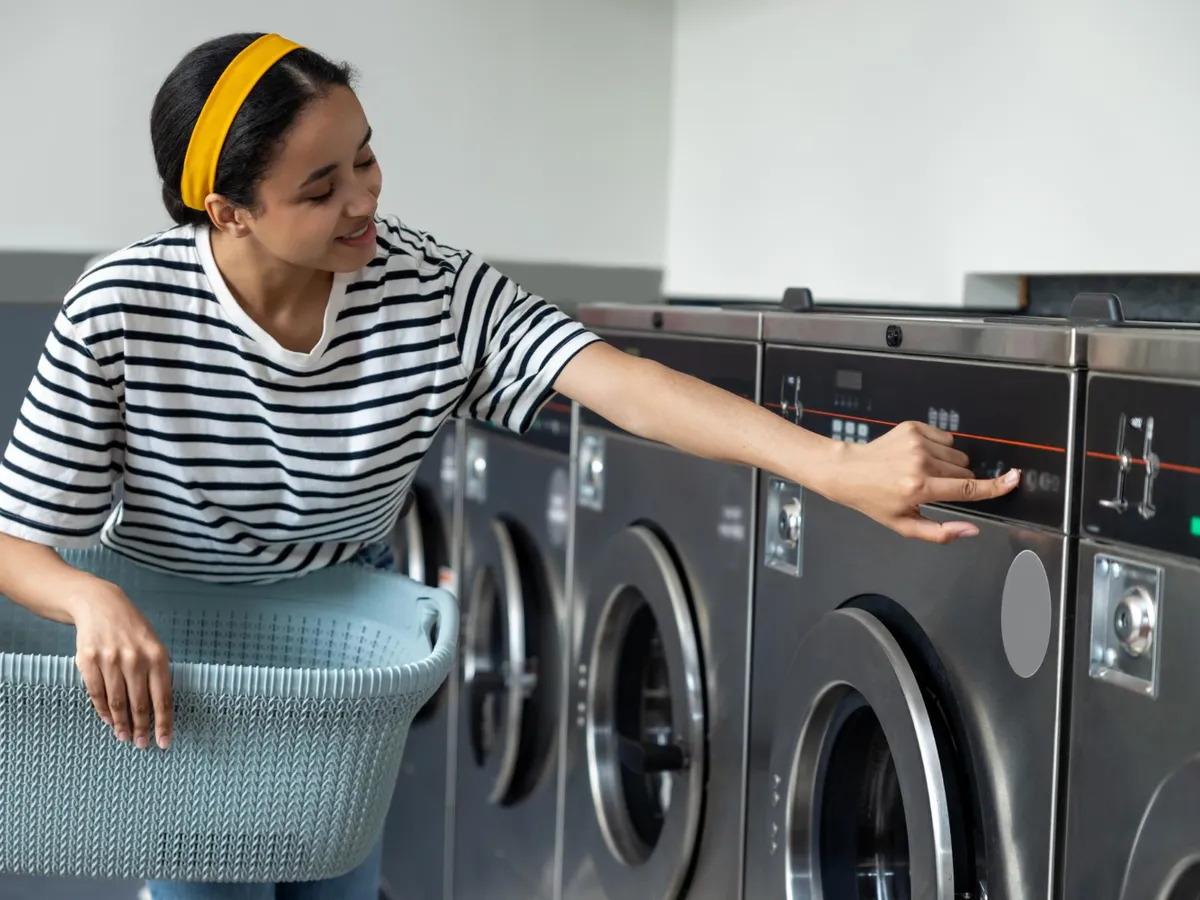 Femeie care pune la spalat rufe - Foto: Freepik (Imagine cu rol ilustrativ)