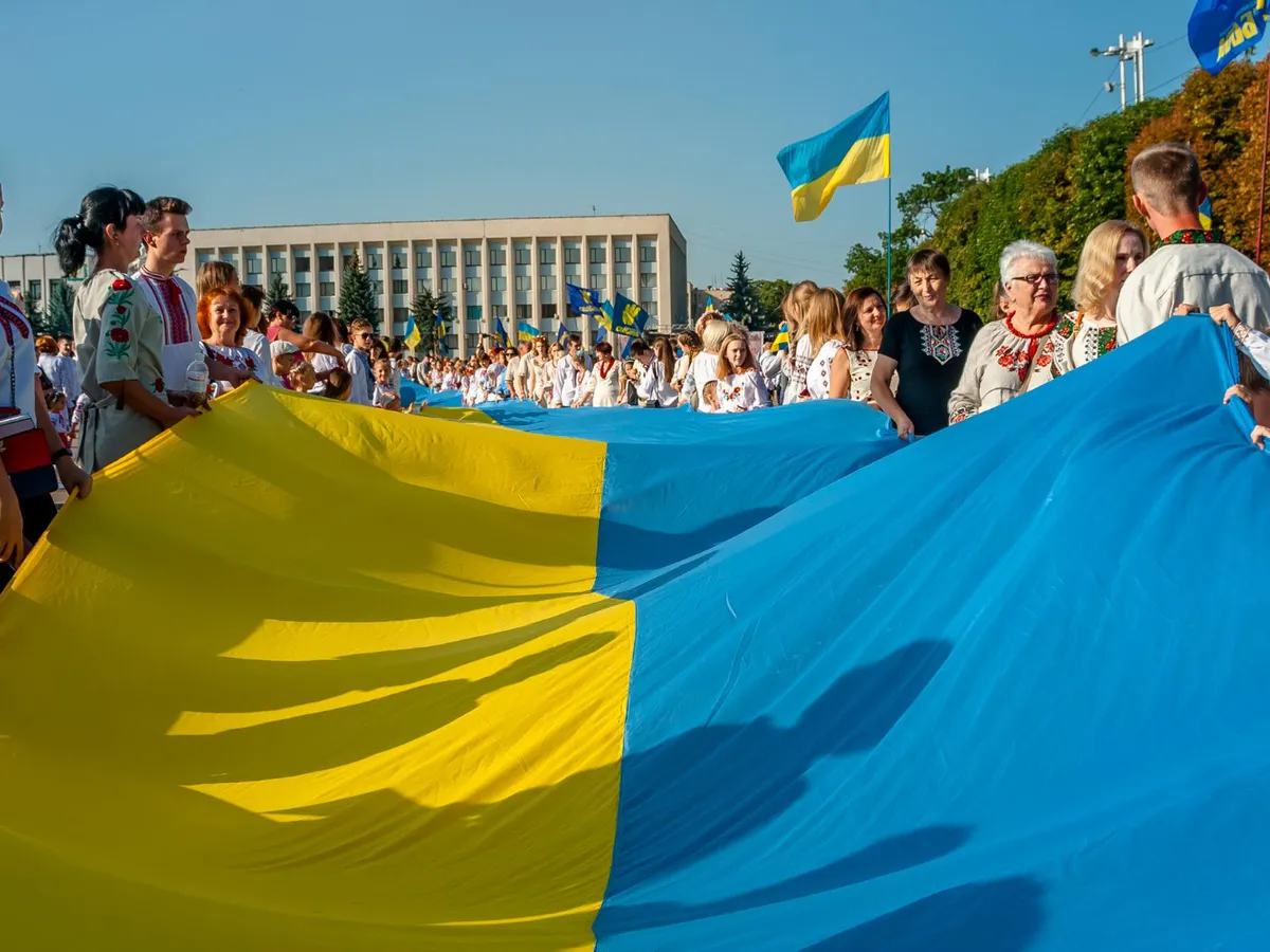 Persoane care țin drapelul Ucrainei - Foto: Freepik (rol ilustrativ)