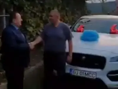 Unchiul Morega, PNL, îl felicită pe nepoțelul Morega, PSD. La mijloc, un Jaguar, neutru. Foto: Captură video