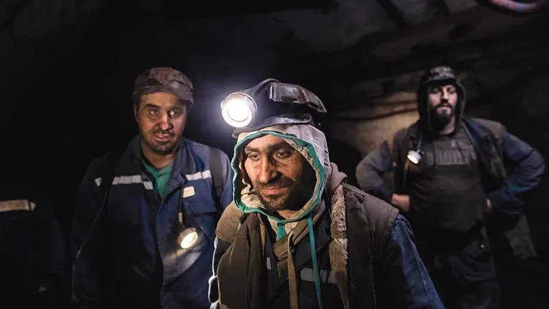 George Ștefoi (stânga), Florin Hașu (mijloc) și Marius Hiciu, așteptând cușca pentru a ieși din subteran la sfârșitul turei lor în mina Vulcan. Brigada Hașu lucrează la 276 m deasupra nivelului mării și mai mult de 350 m sub pământ