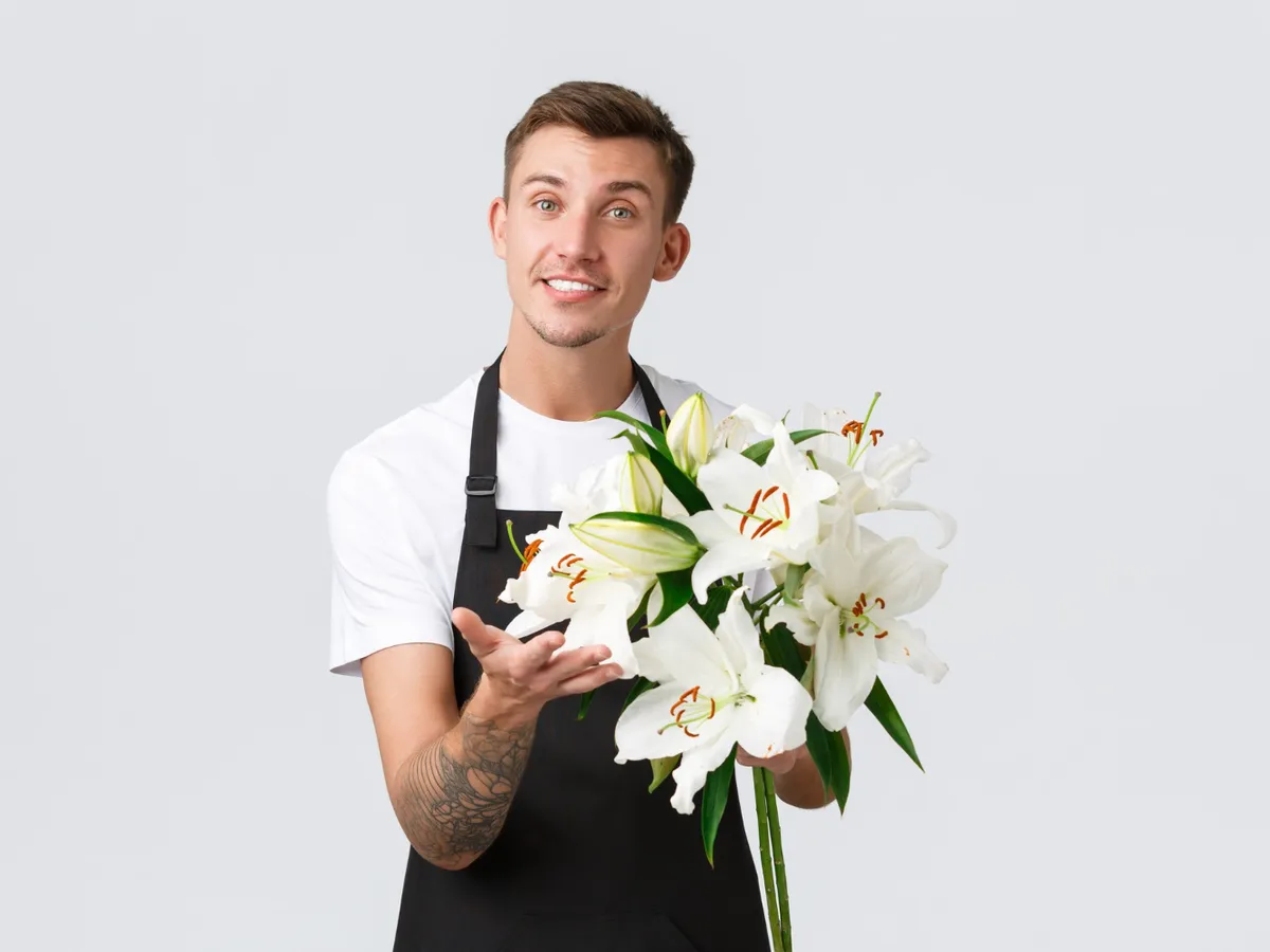 Bărbat cu un buchet de crini - Foto: Magnific.com (Imagine cu rol ilustrativ)