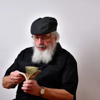 Un pensionar își numără pensia specială - Foto: Freepik