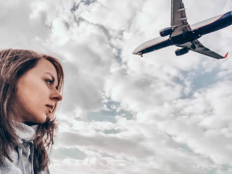 Femeie frumoasă care are deasupra capului un avion - Foto: Freepik (imagine cu rol ilustrativ)