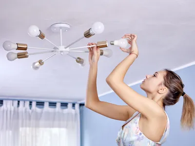 Femeie schimbând becuri - Foto: Freepik