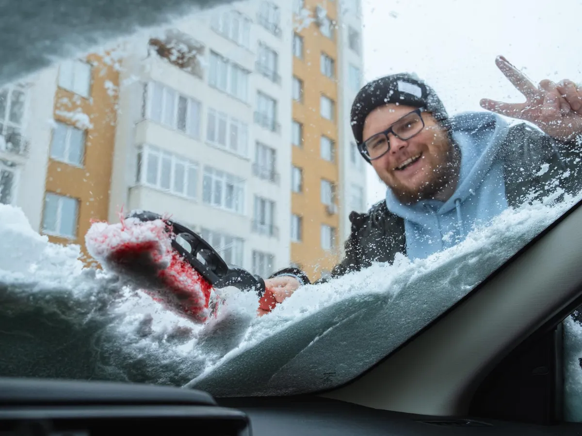 Bărbat care dezgheață geamul și curăță zăpada - Foto: Freepik (Imagine cu rol ilustrativ)
