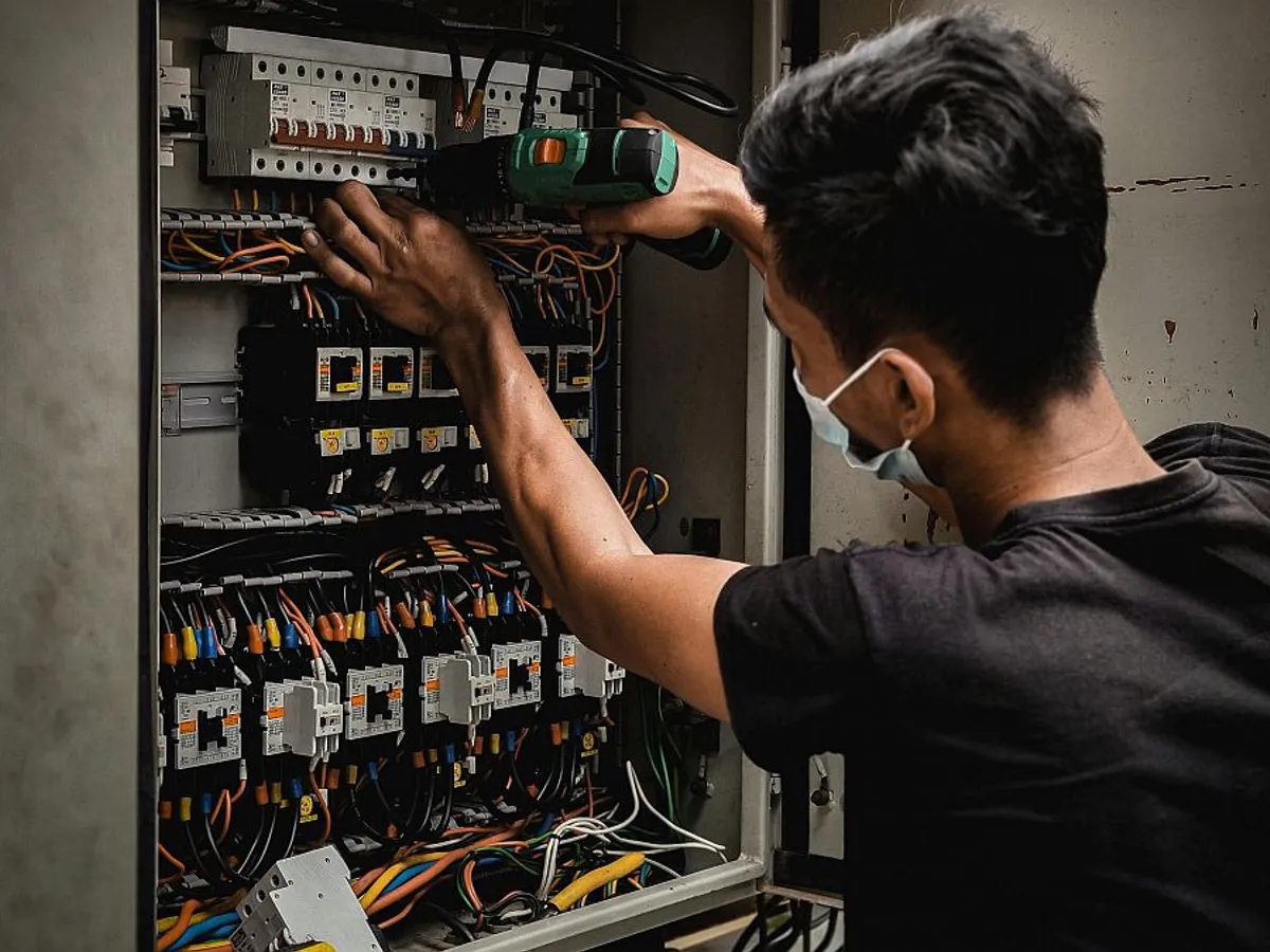 Electrician lucrând la un tablou electric - Foto: Pexels/Aizat Ramlan