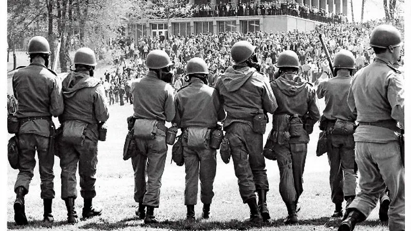 Membri ai Gărzii Naționale din Ohio, cu măști de gaze și baionete, înaintează împotriva studenților care protestează la Universitatea de Stat Kent