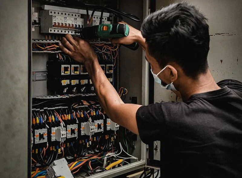 Electrician lucrând la un tablou electric - Foto: Pexels/Aizat Ramlan