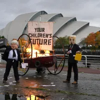 Conferinţa ONU pentru climă: un protestatar deghizat în Boris Johnson a incendiat o barcă. / Foto: thenational.scot