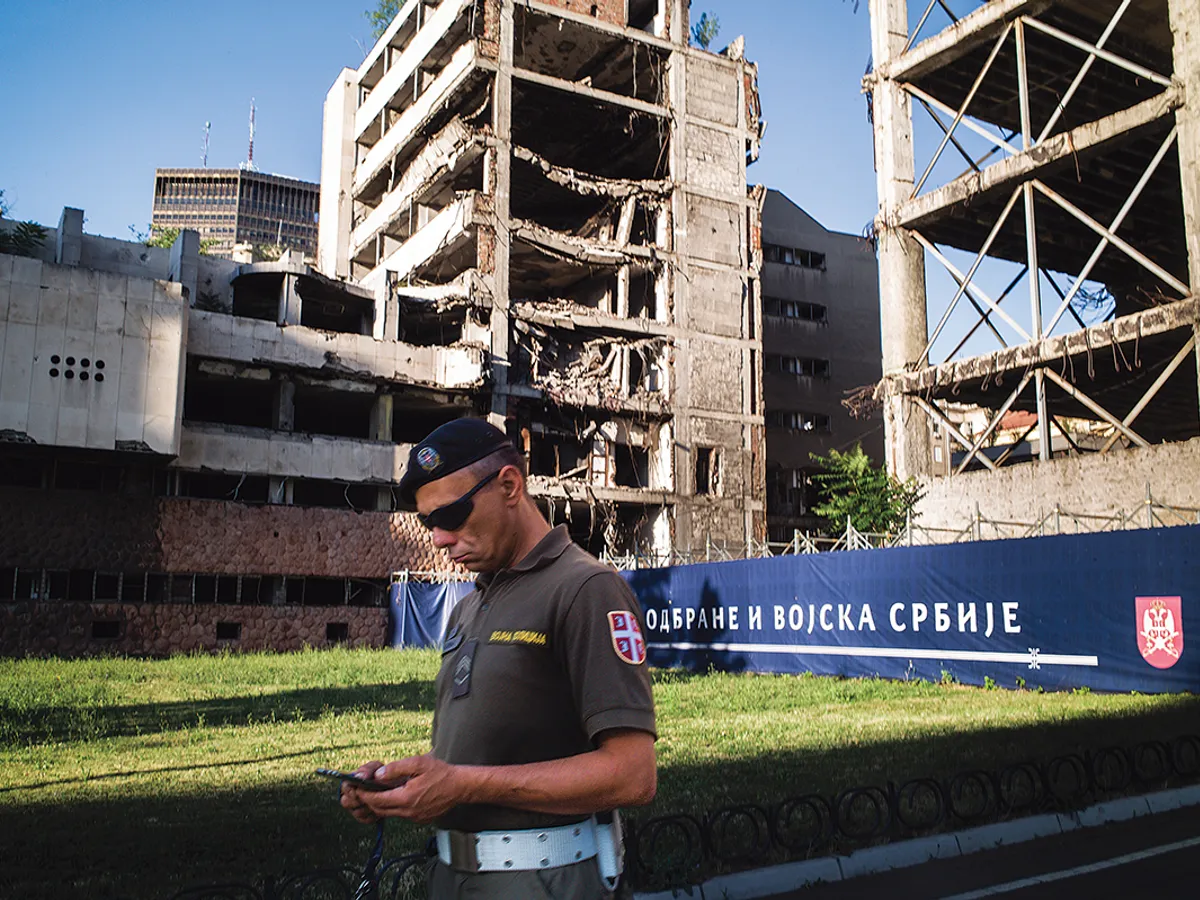 BELGRAD Un soldat trece pe strada Nemanja din Belgrad, pe fundal fiind una dintre clădirile bombardate de americani în 1999