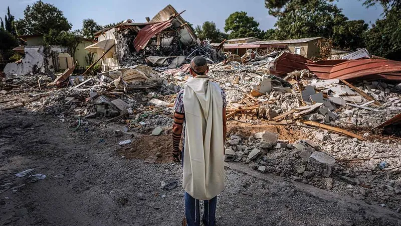 DEVASTARE Un israelian se roagă lângă casele distruse de militanții Hamas în Kibbutz Be’eri, Israel, în octombrie 2023. Aproximativ 1.200 de persoane au fost ucise în atacurile de la începutul acelei luni.