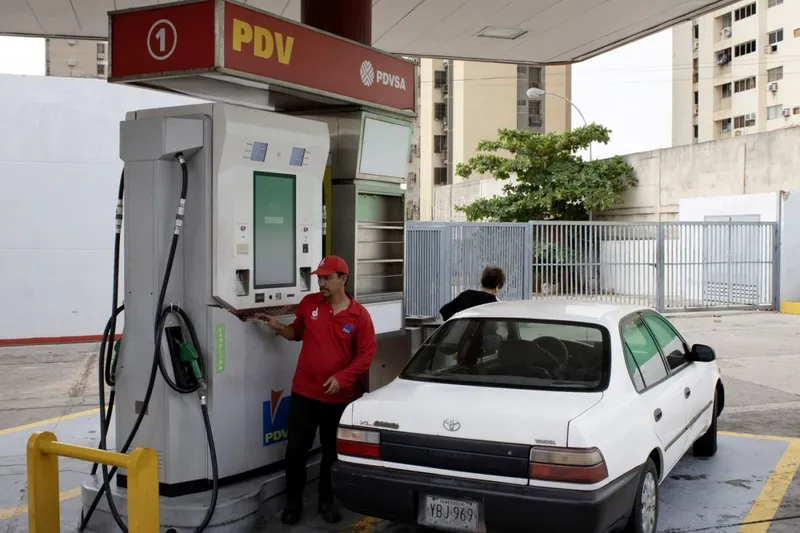 Cum arată sărăcia.O doamnă &icirc;şi pune benzină la o pompă a companiei de stat PDVSA, &icirc;n Maracaibo. Maşina e o Toyota foarte veche - Foto: Profimedia Images