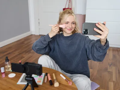 Tânără influencer transmițând în direct o ședință de machiaj - Foto: Freepik (cu rol ilustrativ)