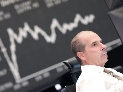 Un trader de la Bursa din Londra urmăreşte evoluţia indicelui DAX al bursei germane - Foto: Profimedia Images