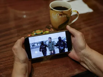 O persoană urmărește un flux de știri cu imagini de la FSB, despre reținerea jurnalistului japonez, acuzat de spionaj - Foto: Profimedia Images