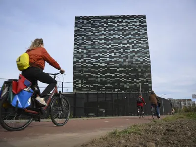 O femeie trece pe bicicletă pe lângă sediul Nexperia, din Nijmegen, Olanda - Foto: Profimedia Images