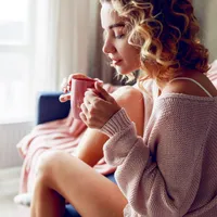 O femeie bea o cană cu apă caldă - Foto: freepik (rol ilustrativ)