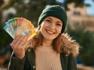 Fată cu un evantai de bancnote euro - Foto: Freepik/krakenimages.com