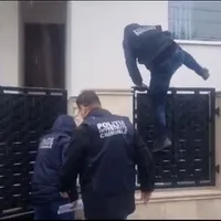 Un poliţist sare peste gardul lui Cătălin Cherecheş - Foto: captură video YouTube/Vasile Dale