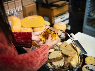 Femeie alegând între mai multe sortimente de brânză tradiţională - Foto: Magnific.com/magnific