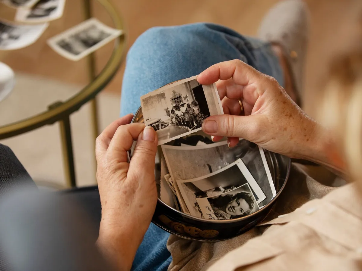 O femeie care ține în mână o fotografie veche cu un strămoș decedat - Foto: Freepik