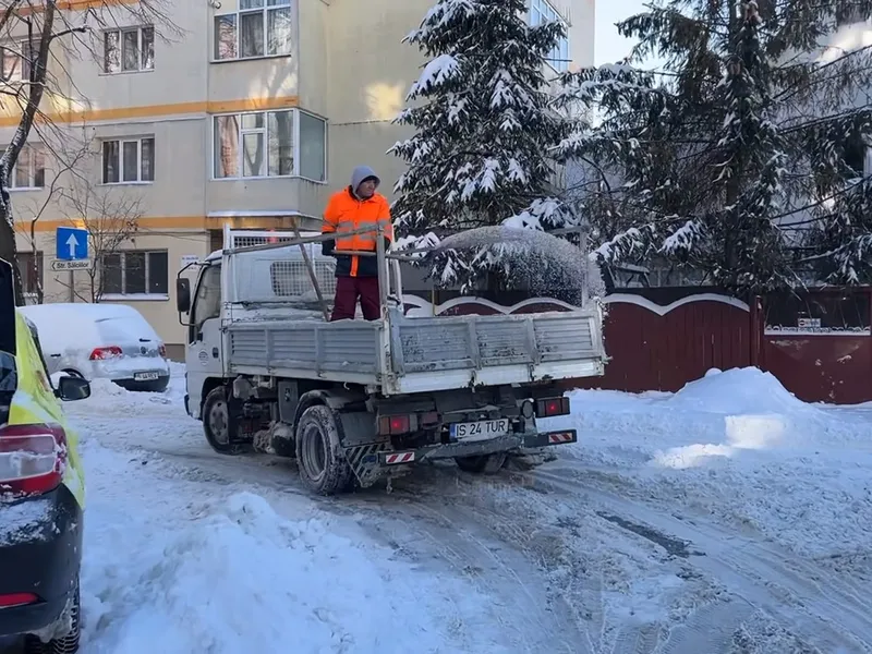 Cum se face deszăpezire „high-tech” în Iași? Se aruncă sare manual, cu lopata, din camionetă - Foto: captură video