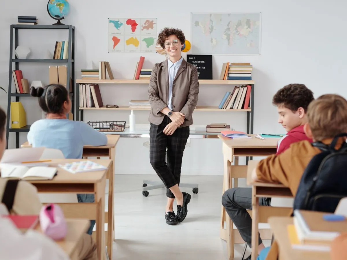 Profesoară stând în faţa clasei - Foto: Pexels/Max Fischer