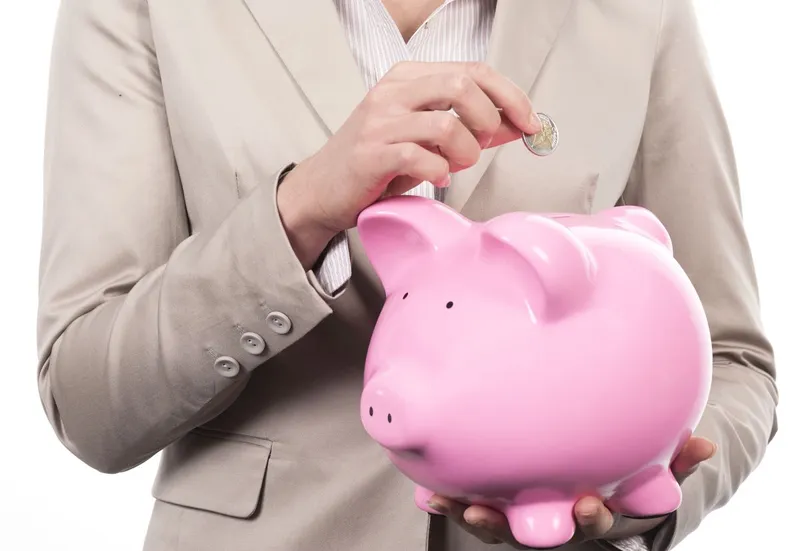 Femeie punând bani la puşculiţă - Foto: Freepik/kues1