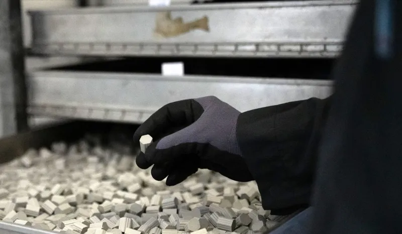 Un angajat scoate o bucată de pulbere propulsivă presată, la uzina Nitrochemie Aschau GmbH - Foto: Profimedia Images